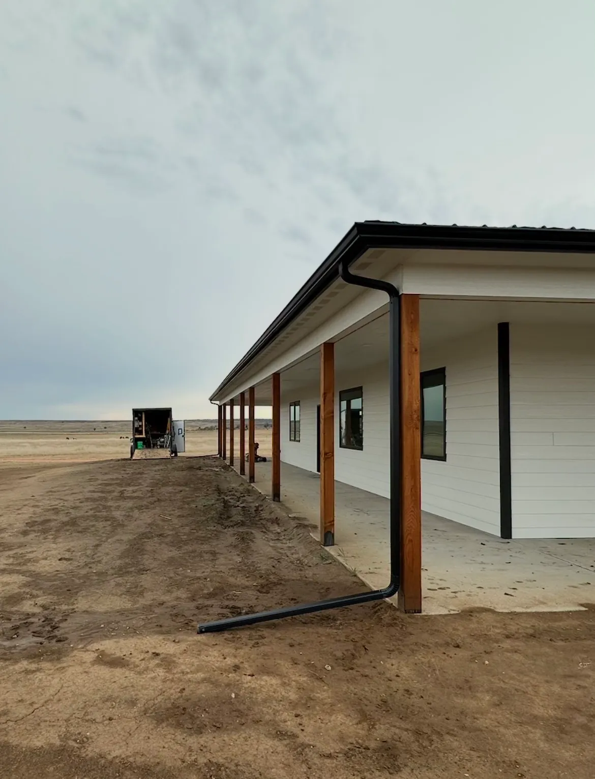 Newly built home with covered porch and black gutters